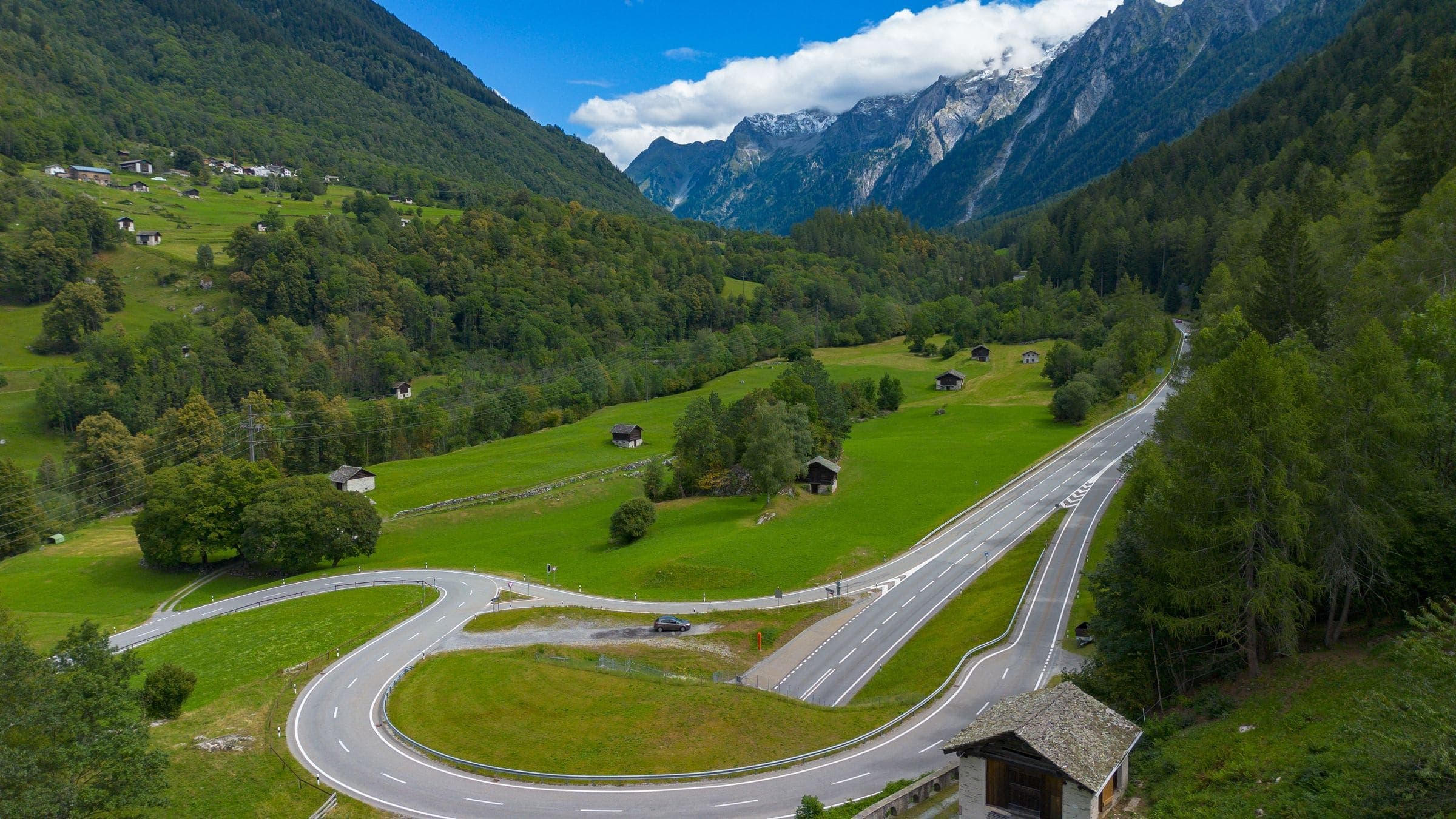 Route de montagne sinueuse dans une vallée verdoyante